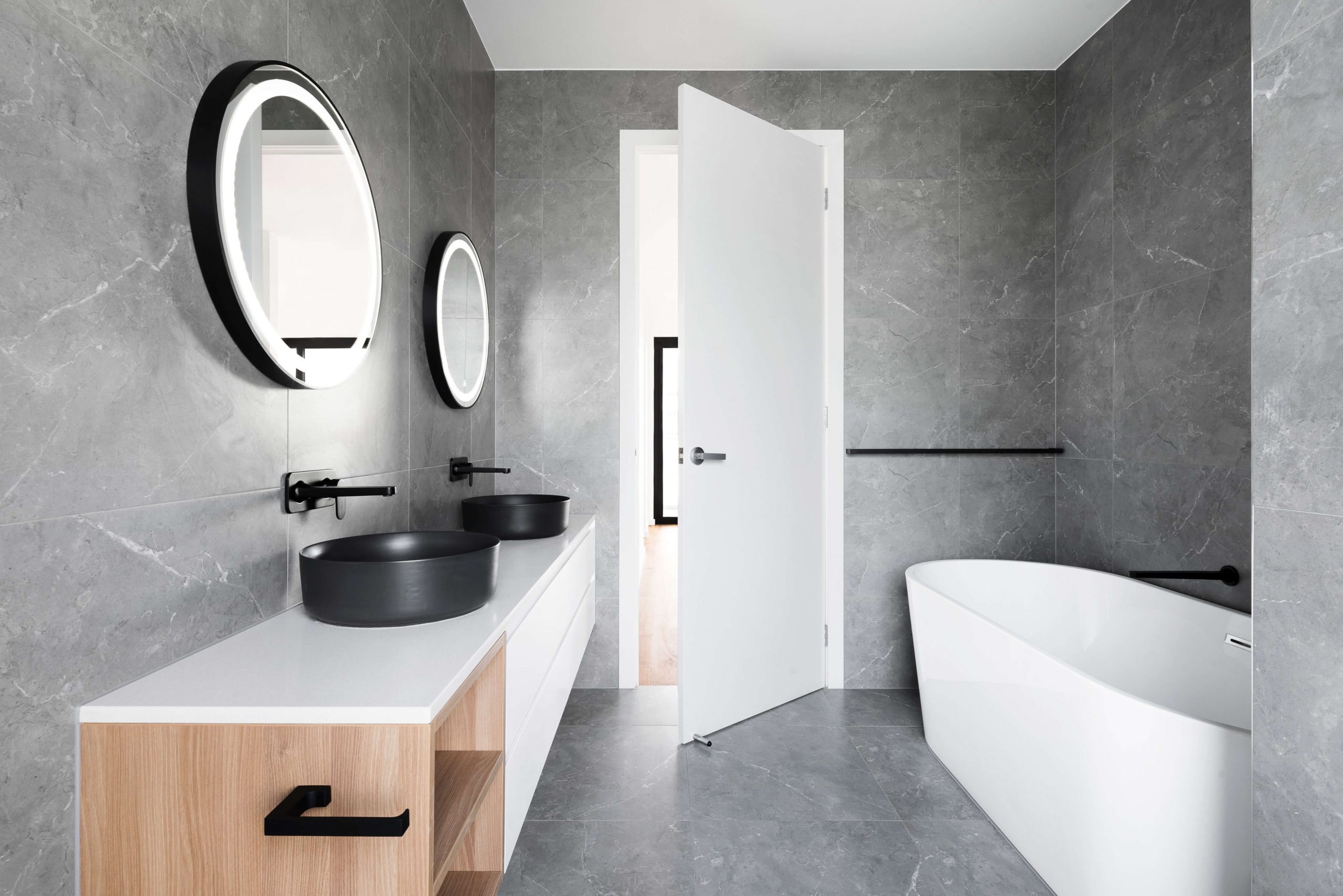 White freestanding bathtub in bathroom with matte black accessories