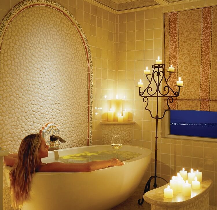 girl bathing in freestanding bathtub with a view