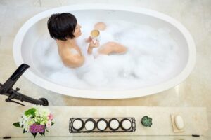 large freestanding bathtub with woman drinking coffee