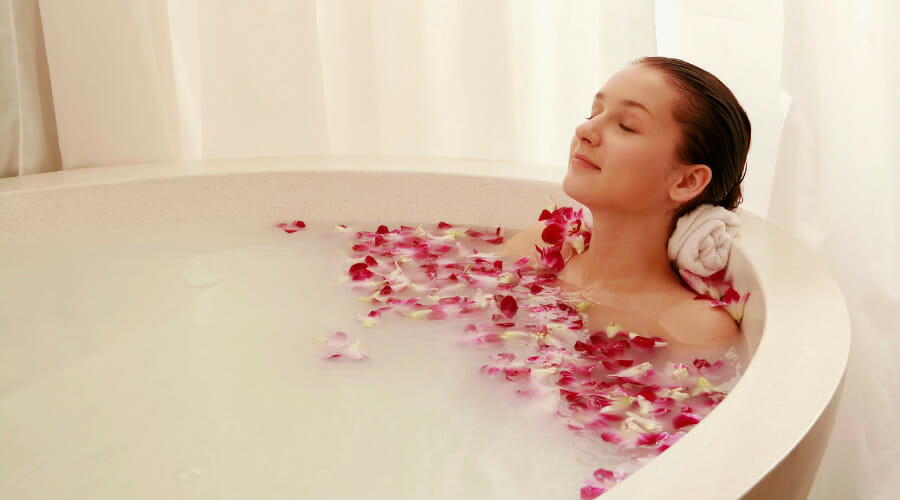 woman soaking in freestanding bathtub